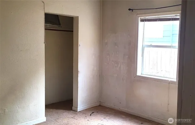 a view of an empty room with a closet