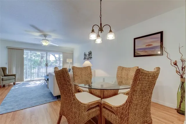 a kitchen with stainless steel appliances granite countertop a sink a stove a refrigerator cabinets and a dining table