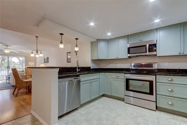 a kitchen with stainless steel appliances granite countertop a stove and a microwave