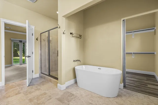 a spacious bathroom with a bathtub sink mirror and toilet