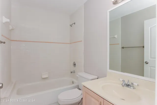 a bathroom with a bathtub shower sink vanity and toilet