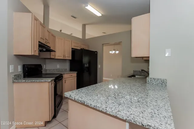 a kitchen with stainless steel appliances granite countertop a sink a stove and a refrigerator