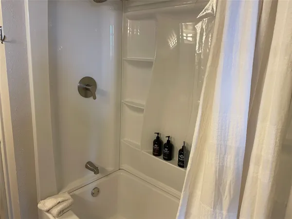a bathroom with a tub and shower