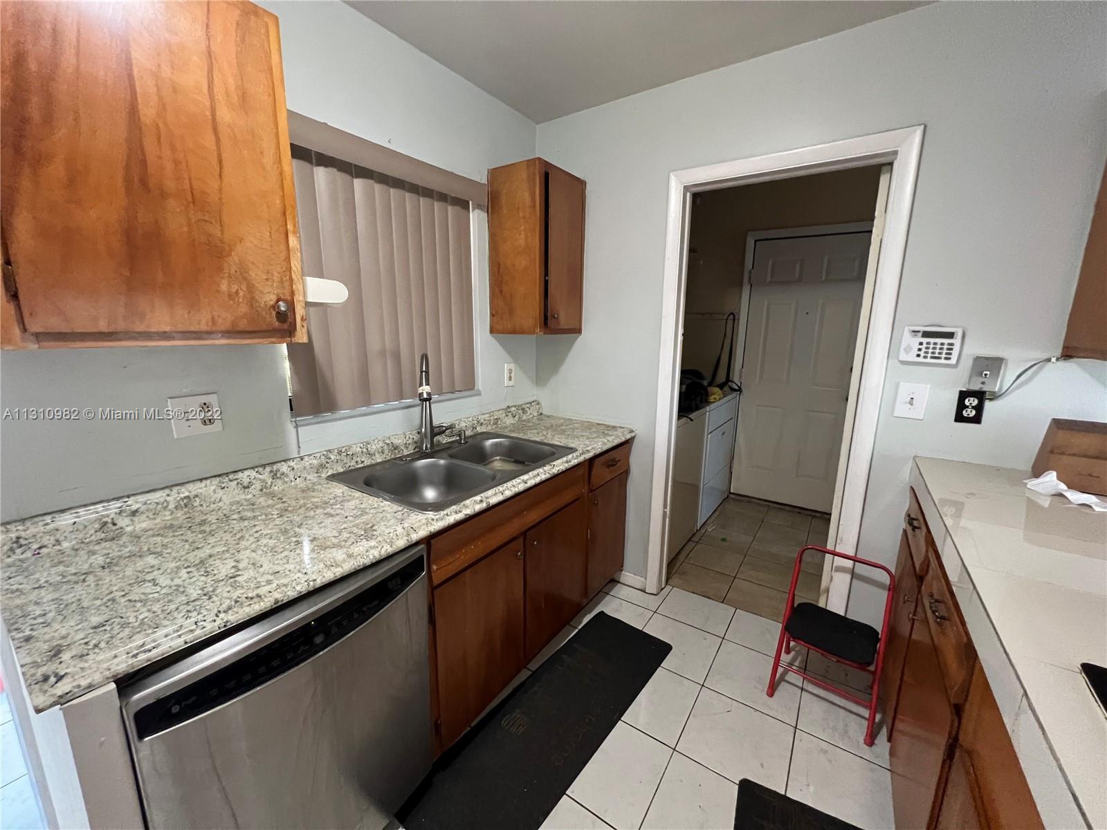 16030 Southwest 99th Avenue Miami, FL 33157 - Photo 13 of 13 a kitchen with granite countertop sink stove and cabinets