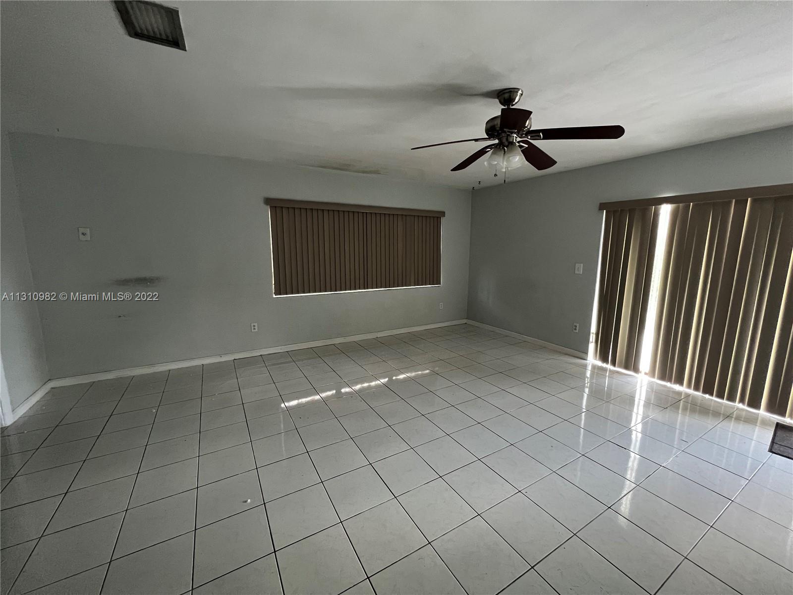 16030 Southwest 99th Avenue Miami, FL 33157 - Photo 8 of 13 an empty room with windows and ceiling fan
