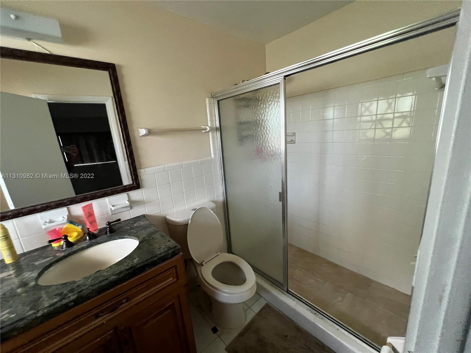16030 Southwest 99th Avenue Miami, FL 33157 - Photo 10 of 13 a bathroom with a granite countertop sink a toilet and shower