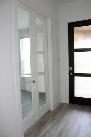 an empty room with wooden floor closet and windows