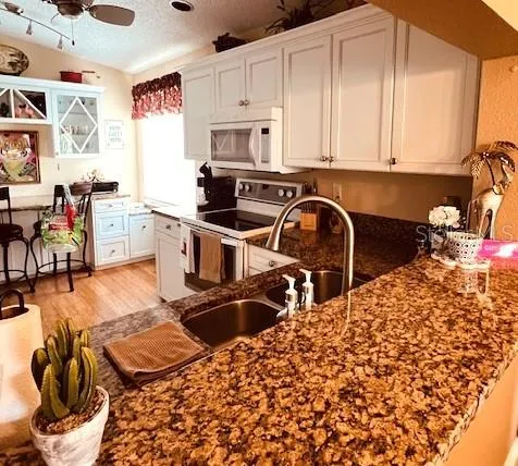 a kitchen with stainless steel appliances kitchen island granite countertop a sink and cabinets