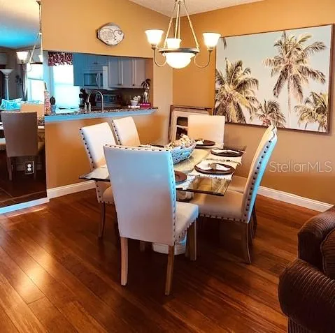 a view of a dining room with furniture a chandelier and wooden floor
