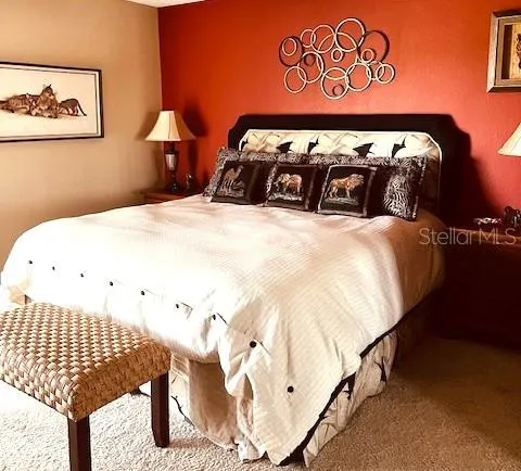 a bedroom with a bed and painting on the wall