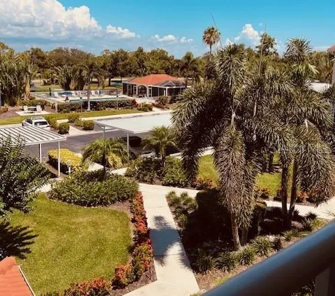 a aerial view of a house with a yard lake and outdoor seating