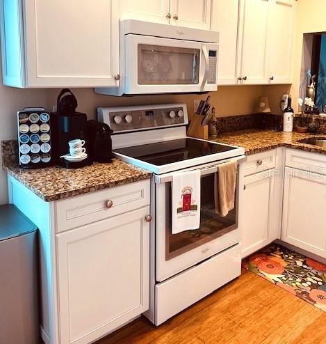 9320 Clubside Circle, Unit 2308 Sarasota, FL 34238 - Photo 7 of 51 a kitchen with granite countertop a stove top oven and cabinets