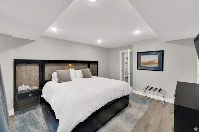 50 Shadow Ridge Road, Unit 4209 Park City, UT 84060 - Photo 16 of 50 Recessed lighting, wood-finish flooring, light gray wall color, and a built-in headboard with integrated lighting