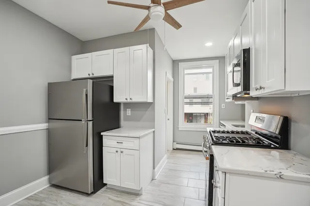a kitchen with a refrigerator and a stove top oven