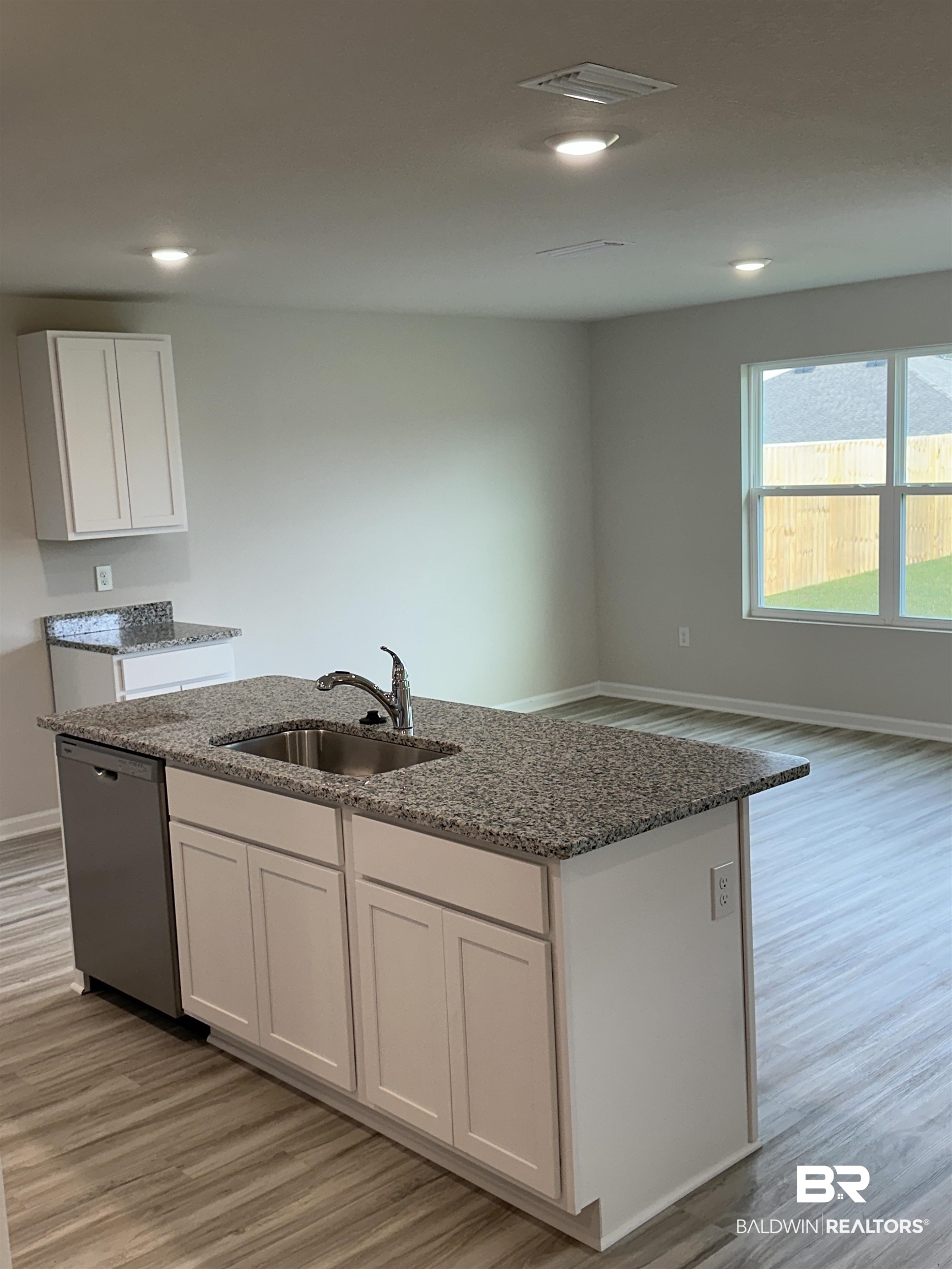 8850 Sea Star Circle Foley, AL 36535 - Photo 24 of 29 Kitchen featuring sink, an island with sink, white cabinets, dishwasher, and light hardwood / wood-style flooring