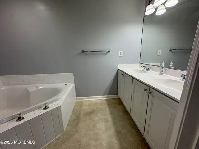 a bathroom with a tub sink and mirror