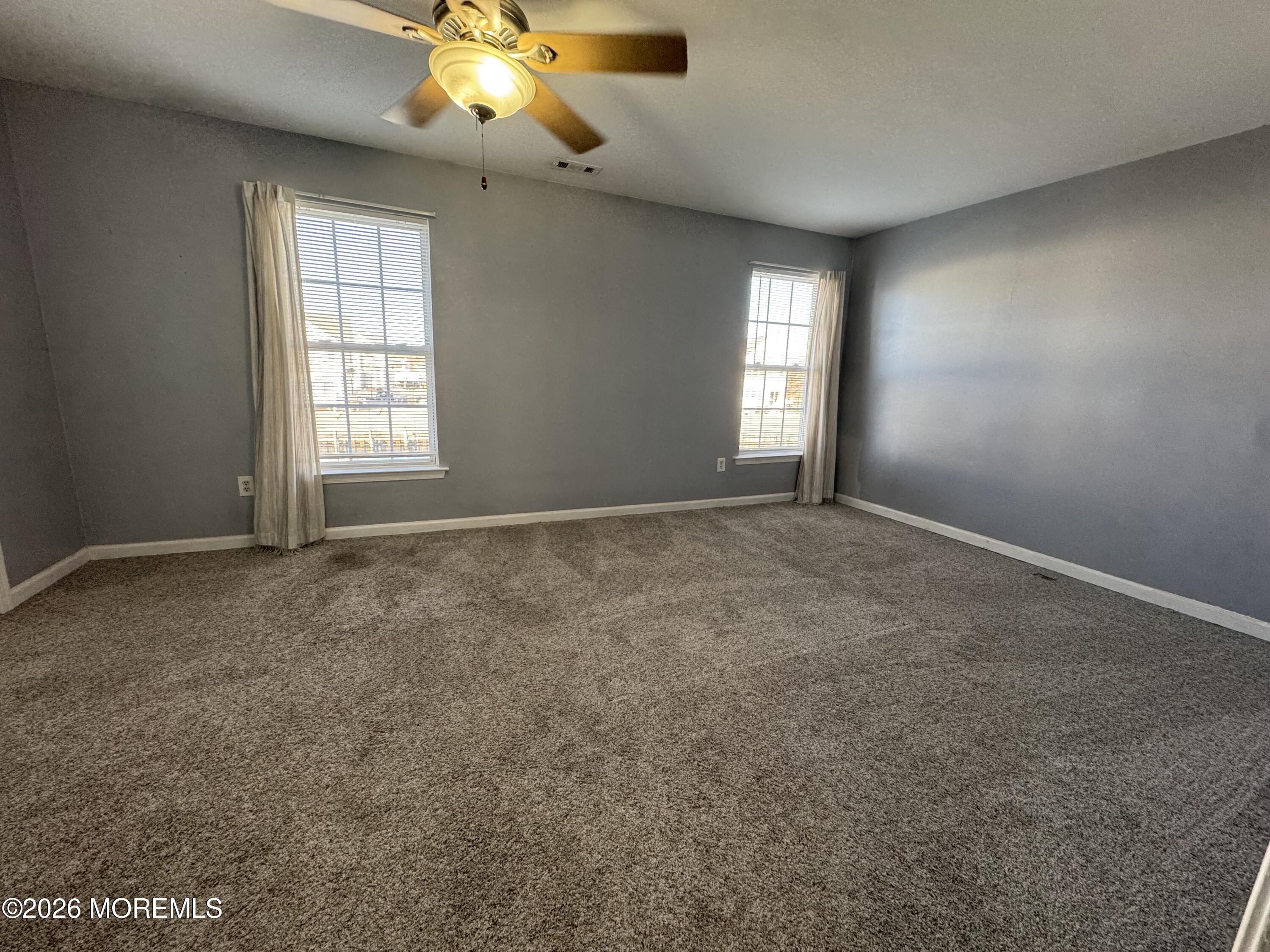 3 Skimmer Lane, Unit 38 Bayville, NJ 08721 - Photo 10 of 14 an empty room with windows and chandelier fan
