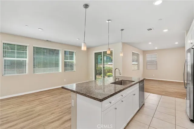 a kitchen with granite countertop a sink and chandelier