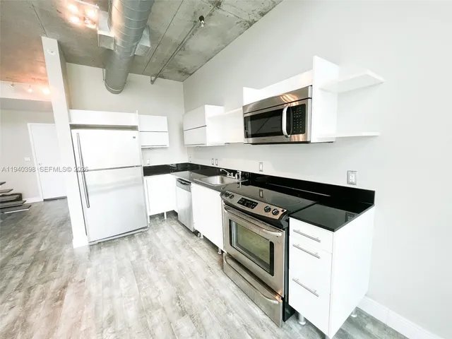 a kitchen with stainless steel appliances a stove microwave and a refrigerator