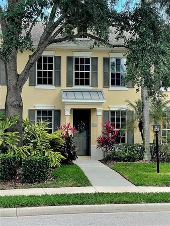 a front view of a house with a garden and trees