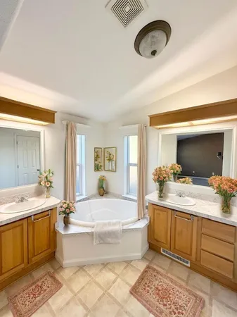 a spacious bathroom with a double vanity sink mirror and bathtub