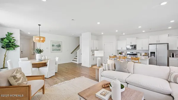 a living room with furniture kitchen view and a chandelier