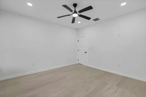 an empty room with a window and a fan