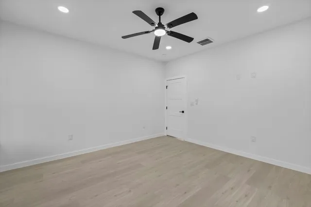 an empty room with a window and a fan