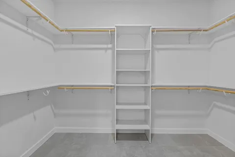 a view of walk in closet with empty racks