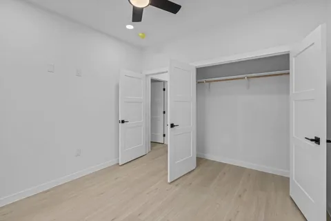 an empty room with a ceiling fan and carpet