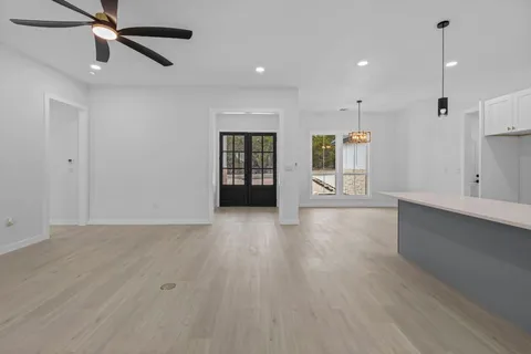 a view of an empty room with window and wooden floor