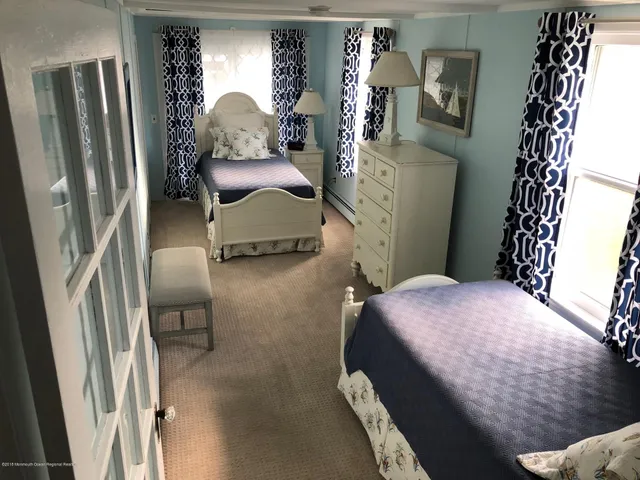 a bedroom with a bed and a mirror on dresser