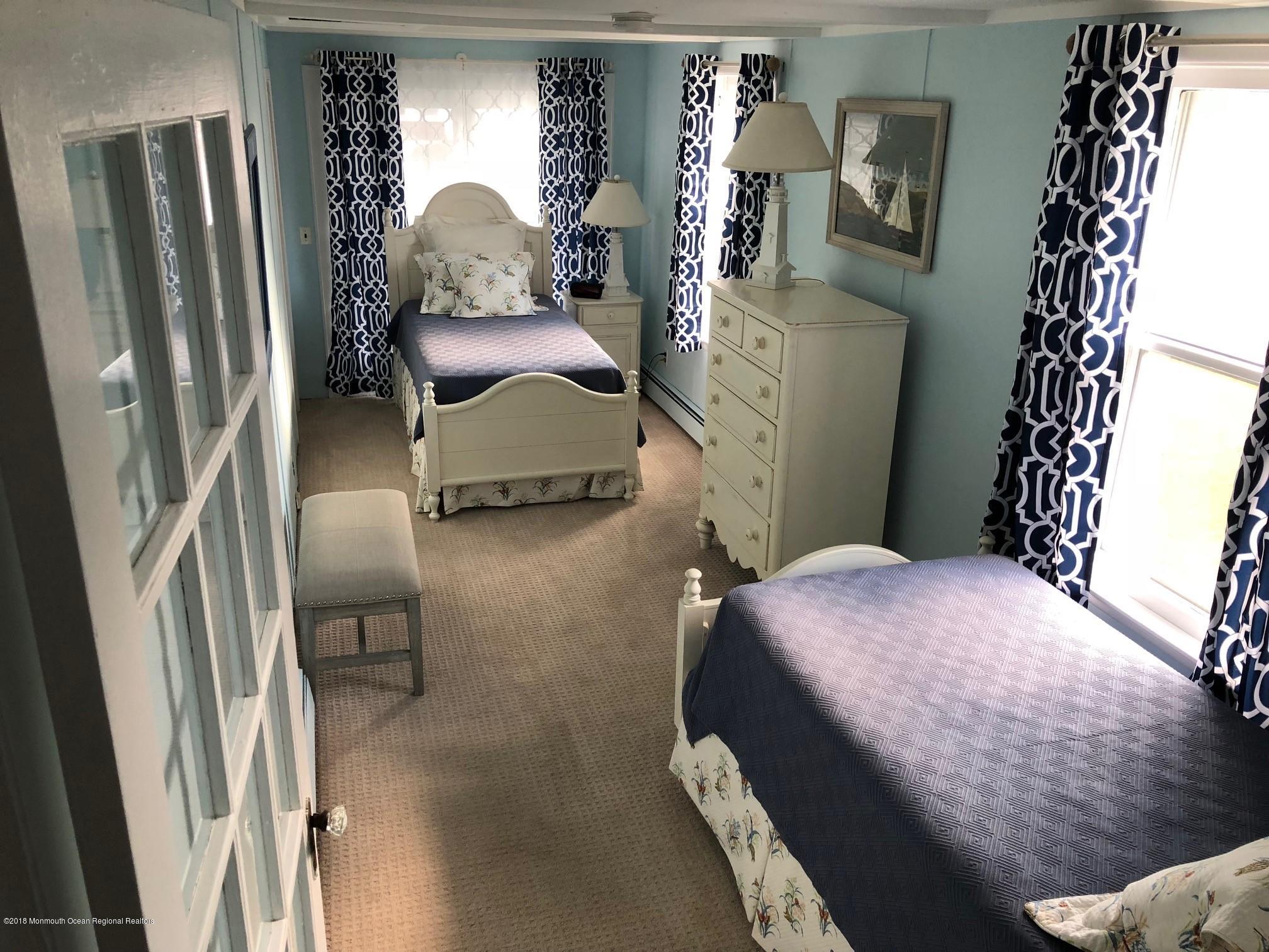 632 Main Avenue, Unit 1 Bay Head, NJ 08742 - Photo 11 of 16 a bedroom with a bed and a mirror on dresser