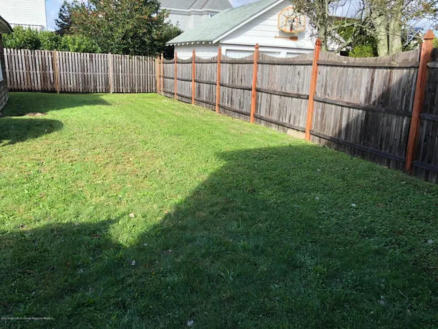 a view of a backyard with a fence and wooden fence