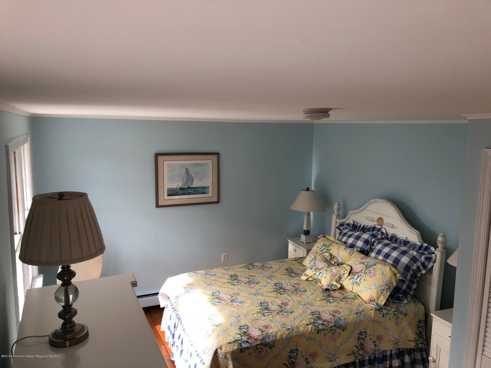 632 Main Avenue, Unit 1 Bay Head, NJ 08742 - Photo 9 of 16 a bedroom with a bed and a lamp