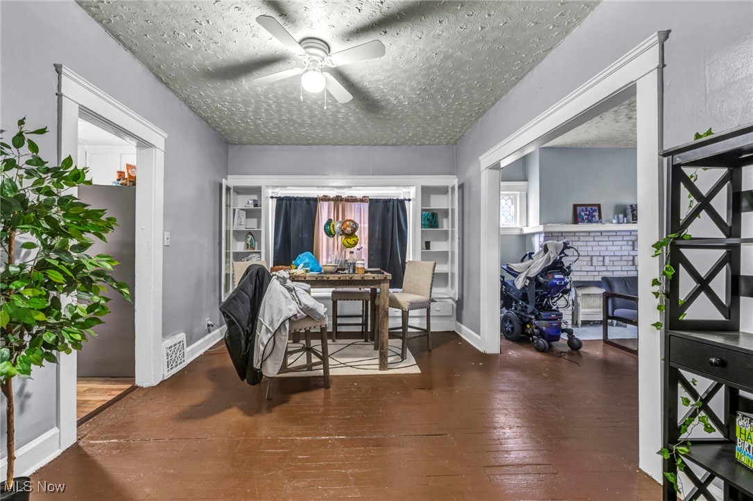 738 Eddy Road Cleveland, OH 44108 - Photo 18 of 33 Dining room featuring dark wood finished floors, a ceiling fan, and a textured ceiling