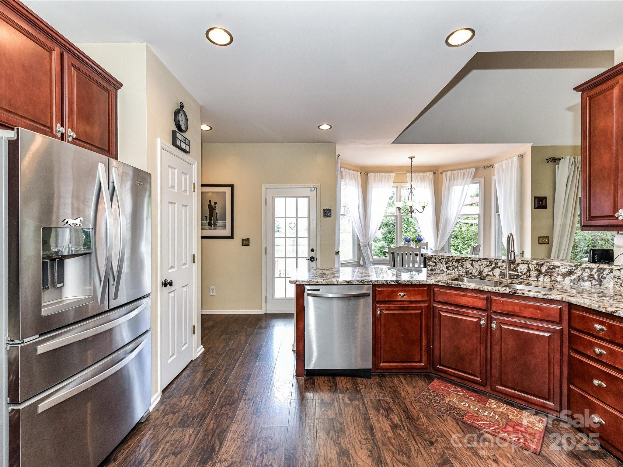 2325 Perry Road Denver, NC 28037 - Photo 18 of 48 a kitchen with stainless steel appliances granite countertop a refrigerator a sink dishwasher a stove and white countertops with wooden floor