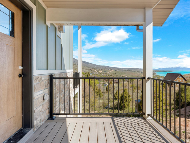 1159 North Broad Hollow Road Garden City, UT 84028 - Photo 13 of 55 Covered porch featuring wood-look decking and black metal railings