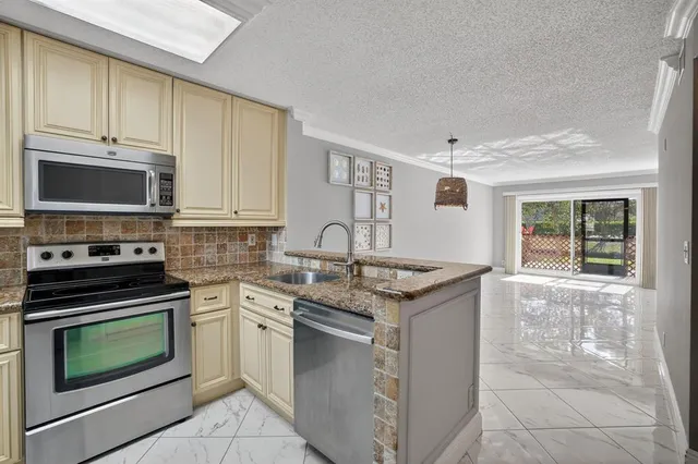 a kitchen with granite countertop a stove top oven microwave and cabinets