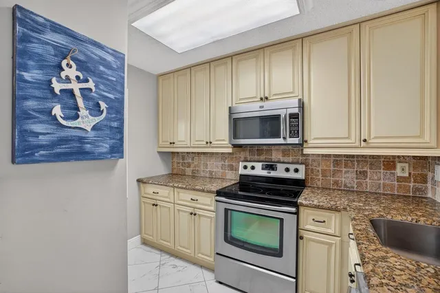 a kitchen with stainless steel appliances granite countertop a stove and a microwave