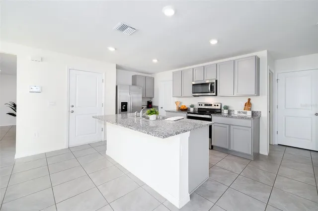 a kitchen with stainless steel appliances granite countertop a sink and a stove