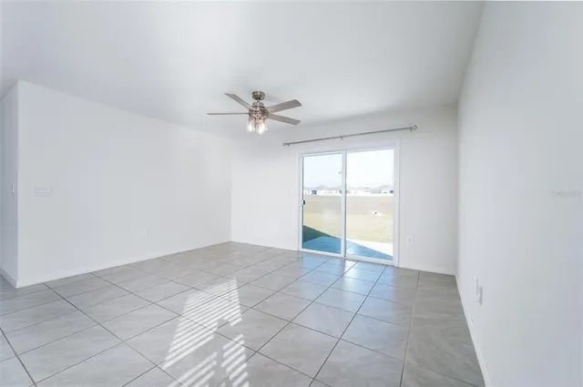 an empty room with fan and windows