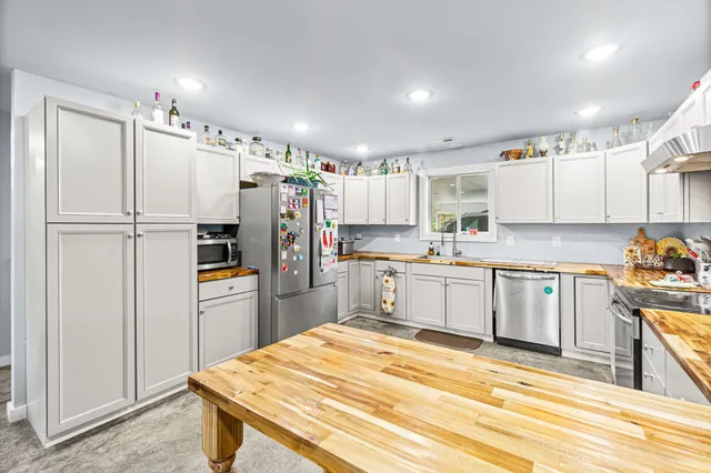 a kitchen with granite countertop a refrigerator stove top oven and sink