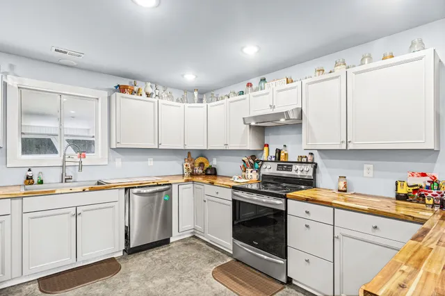 a kitchen with cabinets appliances a sink and a window