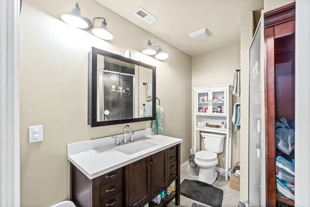 a bathroom with a sink vanity granite and toilet