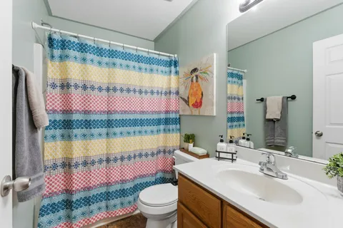 a bathroom with a sink toilet mirror and tub