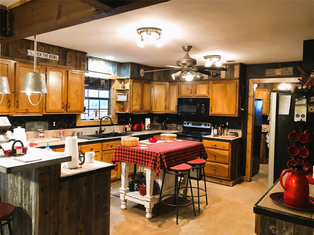 783 County Road 4420 Whitewright, TX 75491 - Photo 11 of 40 a kitchen with stainless steel appliances granite countertop a stove a sink dishwasher and cabinets with wooden floor