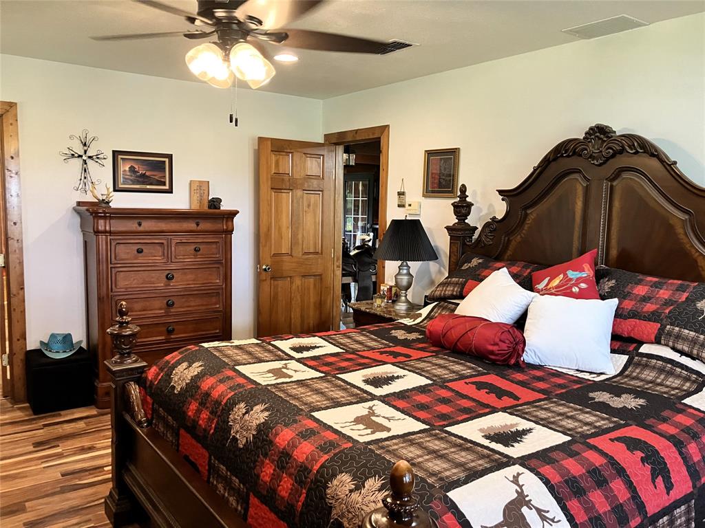 783 County Road 4420 Whitewright, TX 75491 - Photo 14 of 40 a bedroom with a bed and wooden floor