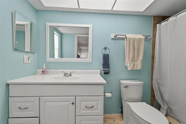 a bathroom with a sink vanity mirror and toilet