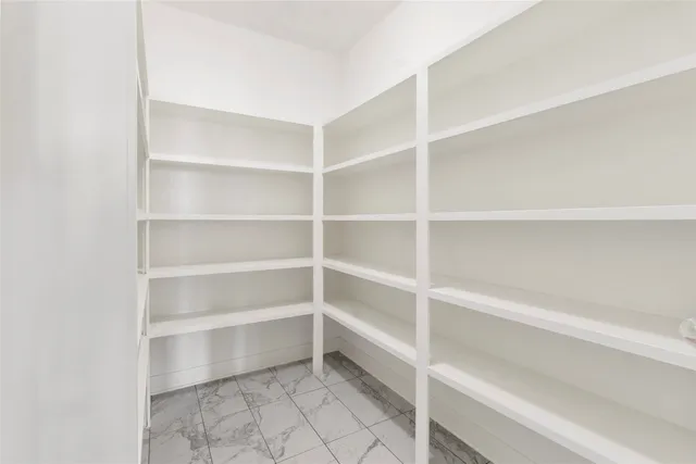 an empty room with windows and ceiling fan